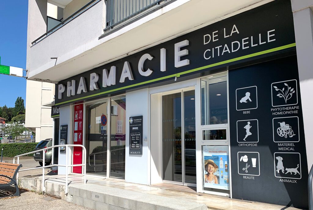 Façade de la pharmacie de la Citadelle à Voiron en rez de chaussée d'un immeuble. Travaux réalisés pour déplacer la porte d'entrée
